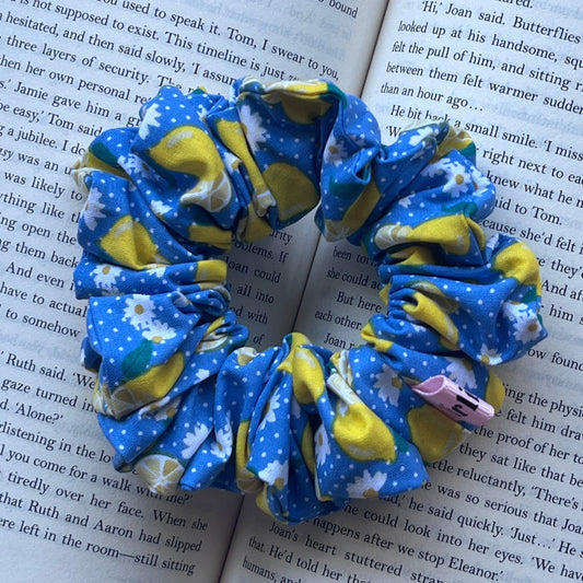 A set of blue and yellow patterned fabric bookmarks shaped like butterflies, displayed on open book pages.